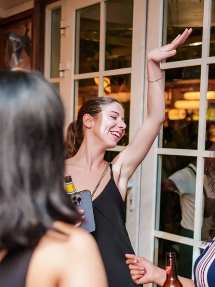 A guest with her hand in the air, fully engaged with the music.