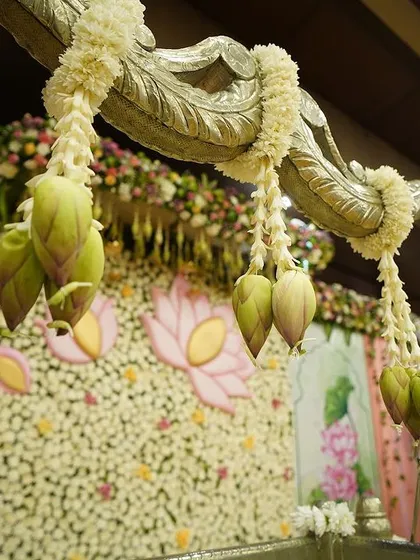 The beauty is in the details. For this lotus-themed event, we hung delicate lotus buds from the cradle structure, adding a layer of texture and traditional charm that enhanced the overall design.