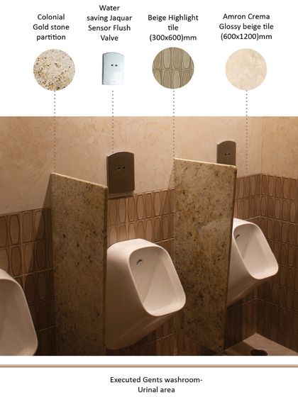 In the urinal area, colonial gold stone partitions provide privacy and a touch of luxury. The design incorporates water-saving sensor flush valves and is complemented by two types of beige tiles, creating a durable and sophisticated finish.