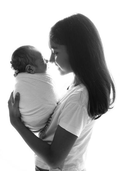 A tender nose-to-nose moment between a big sister and her new sibling. These black and white sibling portraits are incredibly powerful and full of emotion.