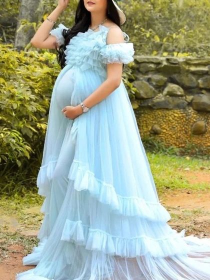 This light blue ruffled gown looks stunning from every angle. The off-the-shoulder design and tiered skirt create a flattering and memorable silhouette for any mom-to-be.