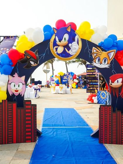 A grand entrance arch for a Sonic party, featuring the main characters and a blue carpet runway to welcome guests at sonic speed.