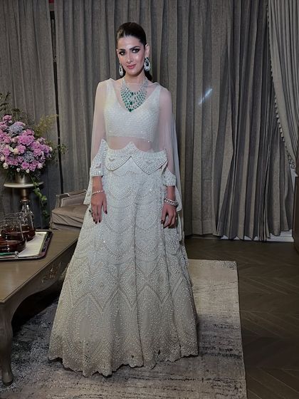 A full-length shot of the client in her beautiful ivory lehenga, looking effortlessly elegant and unforgettable.
