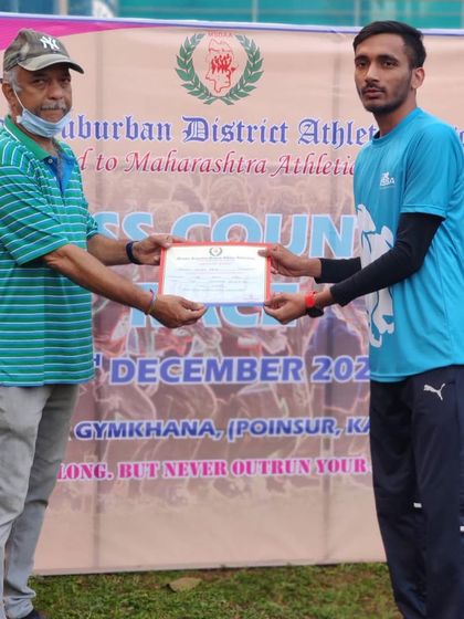 An athlete receiving his certificate for placing in the U/20 8km cross country race organized by MSDAA.