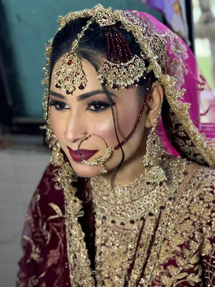 The side profile of this royal bride showcases her intricate jewelry, including the passa and nath. The makeup is bold enough to stand up to the heavy accessories.