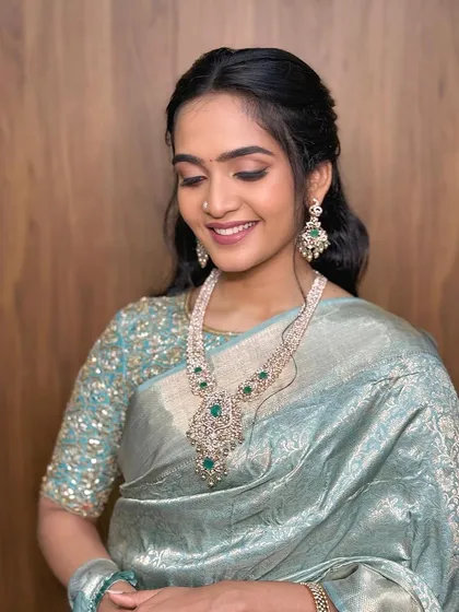 A smiling, eyes-closed shot that shows the delicate eye makeup.