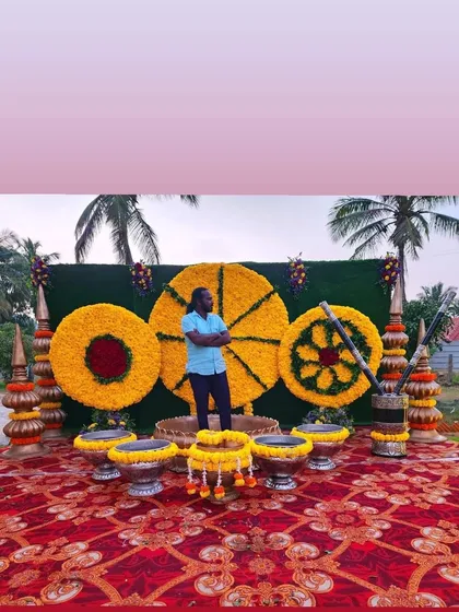 Me standing in front of a Haldi backdrop made of large marigold wheels. This is a unique and creative design for a modern Haldi ceremony.