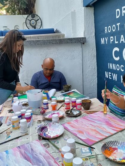 A close-up of my adult students at work, focused on blending colours and bringing their canvases to life in a relaxed cafe setting.