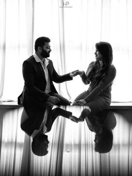 I love playing with light and reflections to create artistic compositions. This black and white pre-wedding photo uses a reflective surface to create a perfectly symmetrical and elegant image that focuses on the couple's quiet connection.