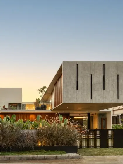 The minimalist facade of the Long House, where clean lines and a restrained material palette create maximum clarity. The cantilevered concrete box with vertical slits is a defining feature of this contemporary Bangalore residence.