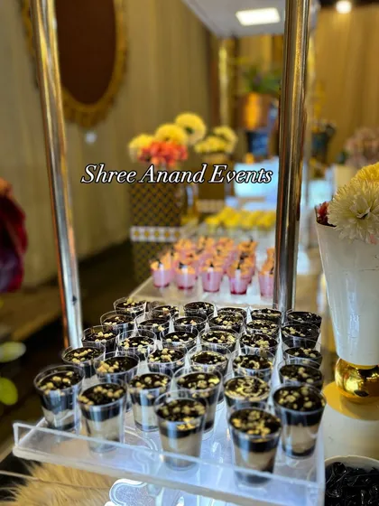 I offer a wide selection of single-serving desserts, perfect for guests to enjoy. This display shows delicious chocolate mousse cups neatly arranged on an illuminated, multi-tiered stand.