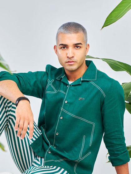 I like my greens in my wardrobe too. This emerald green shirt with contrast stitching, paired with striped trousers, is a bold look from the Antriksh collection.