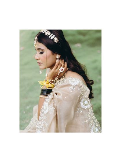 A beautiful close-up of Aishwarya. This portrait highlights the intricate details of her jewelry and the soft, delicate fabric of her bridal outfit.