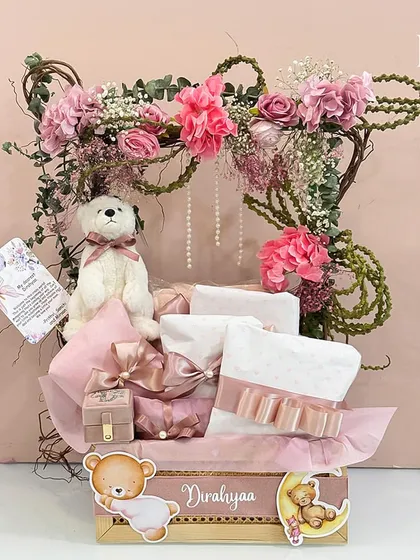 Welcome, little princess Dirahyaa. This personalized hamper is framed by a beautiful arch of pink flowers and vines, creating an enchanting presentation for the soft toys and gifts inside.