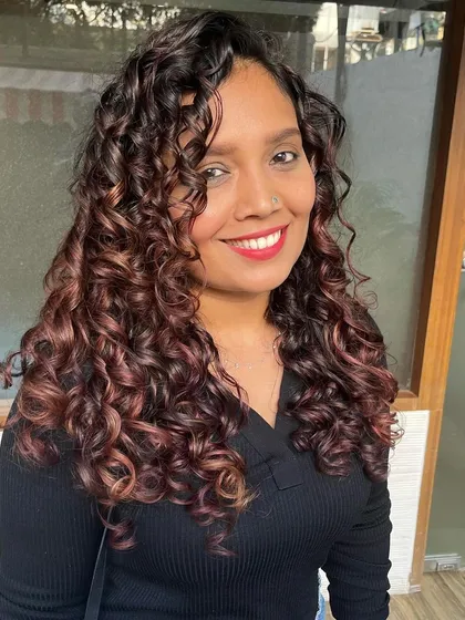 Here’s another look at how color can transform curls. I used burgundy Pintura highlights to give Manali’s long curls incredible depth and vibrancy, finishing with a bond repair treatment to ensure her hair stayed strong and glossy.