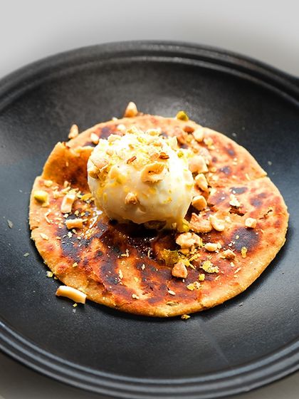 Mawa Mishri Parantha with Ginger Candy Ice Cream. This unique dessert combines a sweet, rich paratha with the spicy kick of ginger ice cream, a nod to the culinary traditions of Rajasthan.