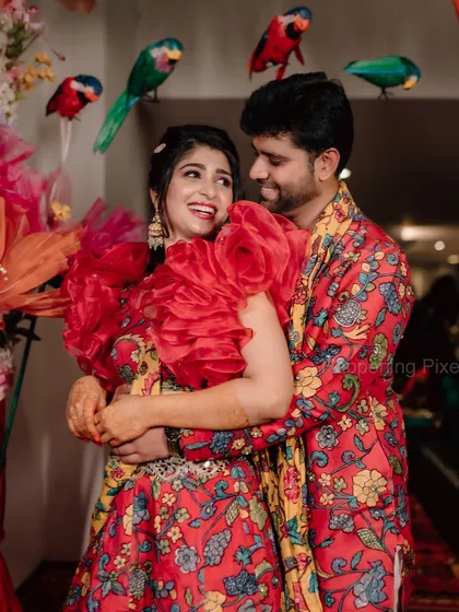 Another happy shot of the couple at their Mehendi. The custom-made parrot props hanging in the background added a playful and unique touch to the decor.