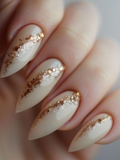 Nail inspiration for an elegant look with a nude base and a diagonal sweep of gold foil and glitter.