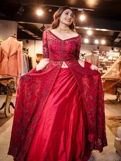 A candid, happy moment captured during a couture shoot. The model's joyful expression while wearing this red layered gown shows that high fashion can also be about celebration and personality.