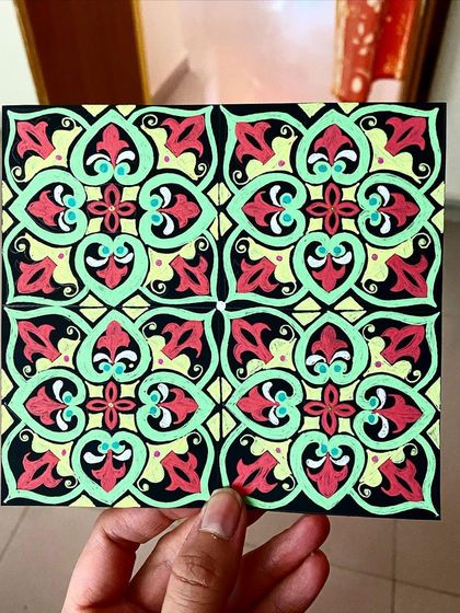 This piece is a tessellation, which is a repeating pattern of shapes without overlaps or gaps. I created this colorful tile design using markers on black paper.