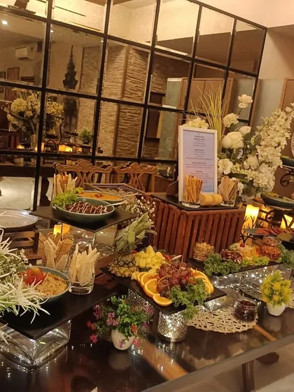 Dream settings for any event. This elegant buffet setup combines beautiful florals, ambient lighting, and a delicious array of food to create a sophisticated atmosphere.