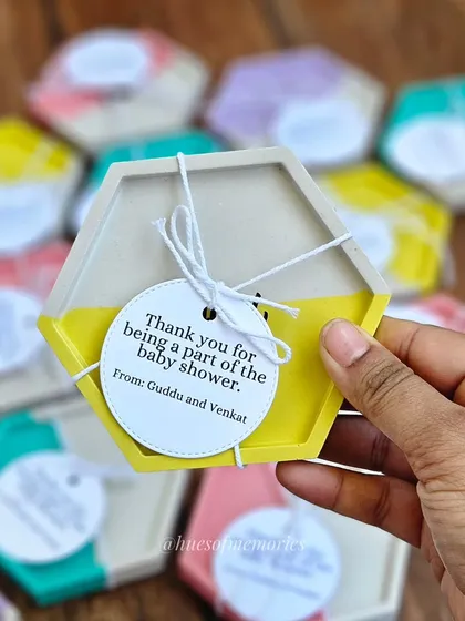 These custom hexagon coasters were made as return gifts for a baby shower. The half-and-half pastel yellow and white design, complete with a personalized tag, makes for a thoughtful and unique party favor.