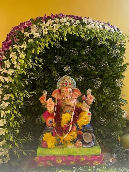 A beautiful arch of fresh orchids and other exotic flowers creates a lush and natural canopy for Bappa. This design is perfect for those who want a sophisticated and nature-inspired mandap.