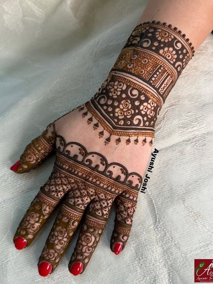 A stylish back-hand design for a bridesmaid, featuring a border of elephants and delicate floral patterns.