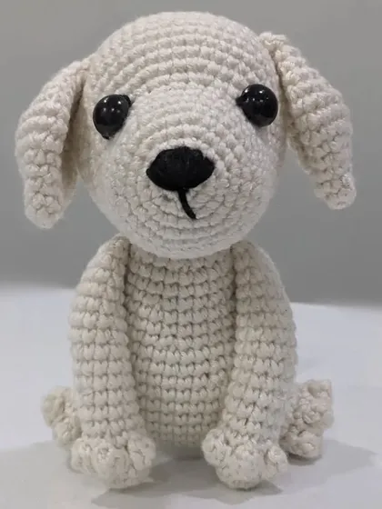 A front-facing view of the white crochet puppy, named Milky.