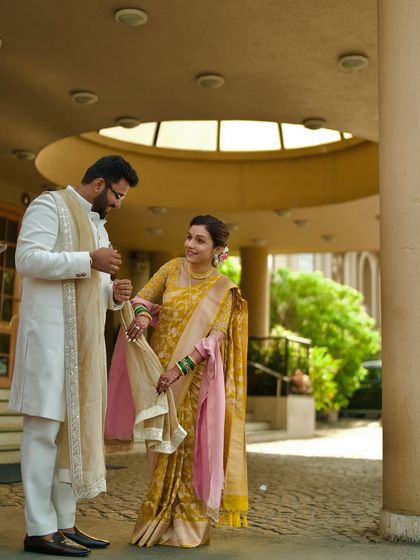 A playful moment between the couple, with the groom holding the bride's saree pallu. These small, fun interactions make for great photos.