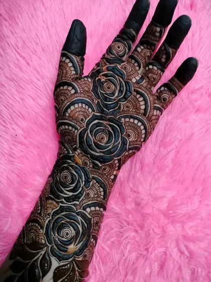 A dramatic design featuring large, 3D black roses against a fan-like background pattern.