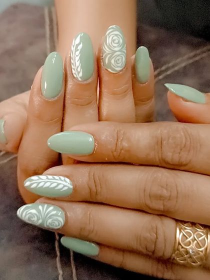 A beautiful sage green set with intricate white hand-painted rose and leaf designs.