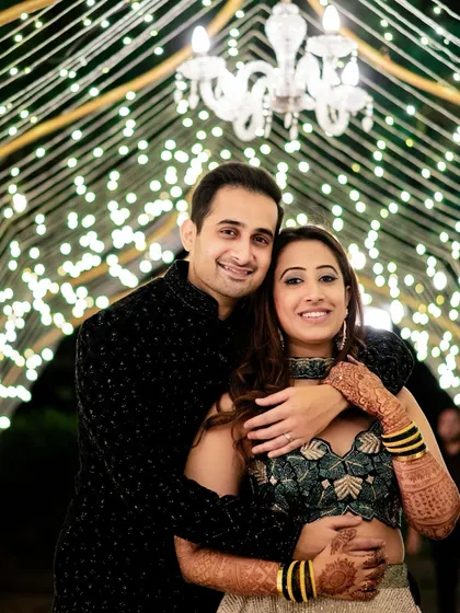 A romantic portrait of the couple at their Sangeet in Lonavala, set against a beautiful backdrop of fairy lights.