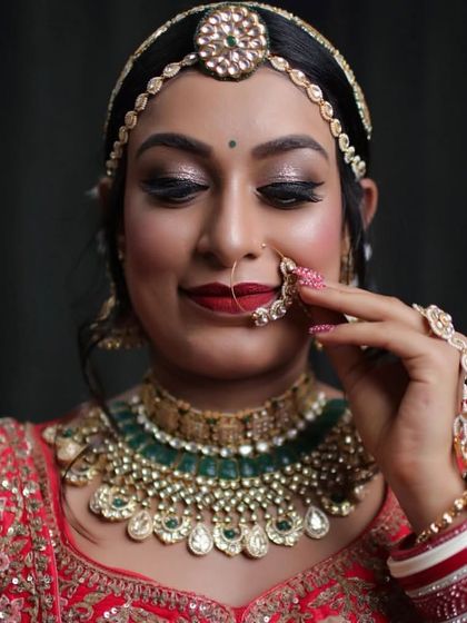 A close-up of the bride adjusting her nath, a key part of the traditional bridal set.