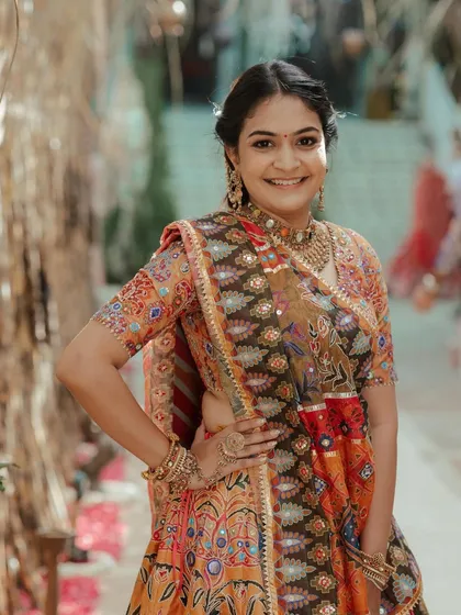 The smiling client, looking radiant for the pooja ceremony with her intricate hairstyle.
