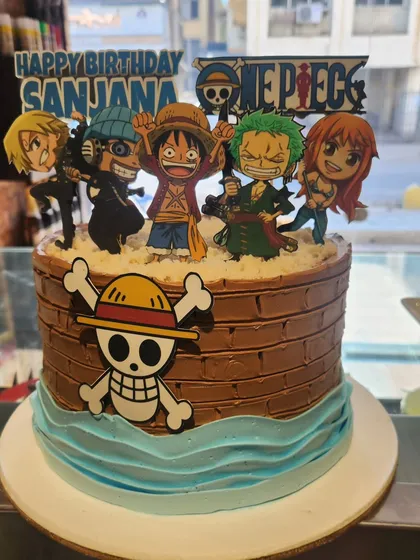 Set sail on a sweet adventure with this One Piece anime cake. The design features a chocolate "barrel" tier, blue buttercream waves, and the Straw Hat Pirates crew, ready for a pirate-themed party.