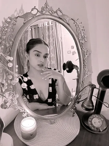 A mirror selfie with a vintage phone. This photo blends a modern look with a classic aesthetic, much like how I mix new sounds with timeless tracks in my sets.