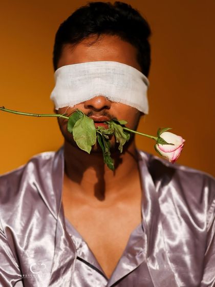 A powerful conceptual portrait about perception. The blindfold obscures sight, but the rose held in his mouth suggests other senses and forms of expression are heightened.