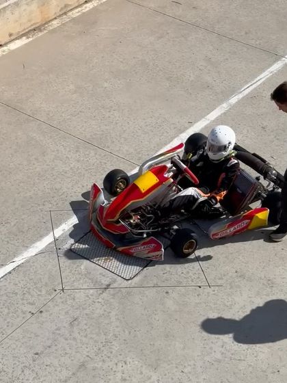 A driver and coach discussing strategy in the pit lane in Spain.