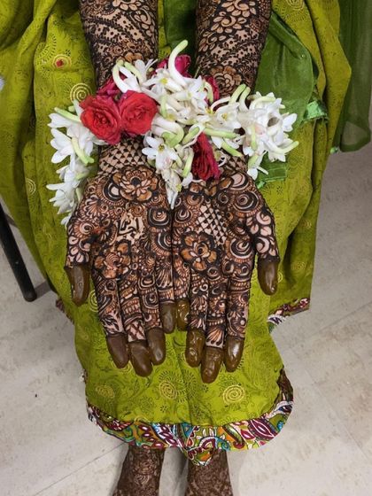 More views of Fathima's bridal henna, showing the personalized name and the stunning floral jewelry that completes the look.