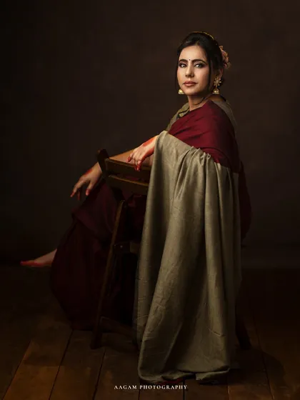 Seated with grace, this portrait showcases the beautiful drape of the saree and her elegant posture.