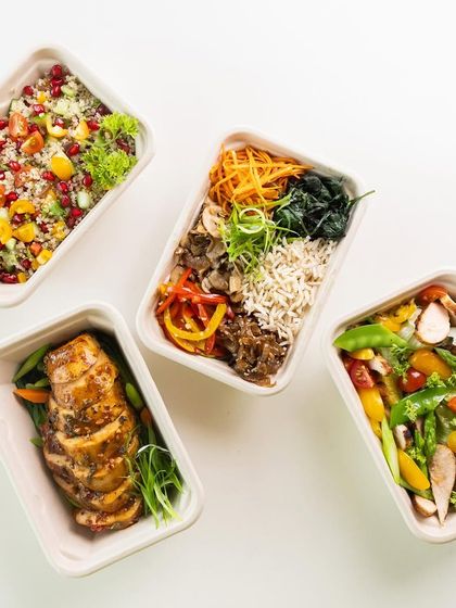 A top-down view of some of our most popular meal boxes. You can see the variety we offer, from quinoa salads to grilled chicken and bibimbap-style bowls, all ready to eat.