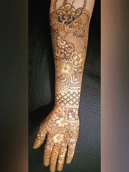 A full-arm bridal design with a focus on floral and vine motifs. The patterns are delicate and flow organically up the arm, creating a romantic look.