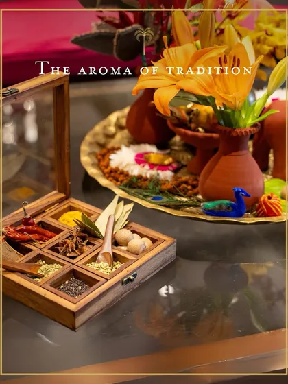 The aroma of tradition. A classic Indian spice box, or 'masala dabba', is displayed as a decorative piece, symbolizing the authentic flavours at the heart of our cooking.