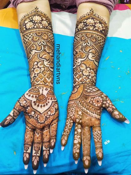 An elegant full-hand design perfect for an engagement or bride. The patterns are symmetrical and feature a mix of floral and traditional motifs.