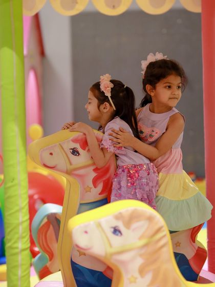 Two friends share a hug on the carousel. Our play area is full of opportunities for sweet, memorable moments.