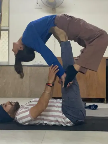 A classic Acro Yoga pose, the 'back bird', which helps open the chest and spine for the flyer. As the base, I ensure stability and support throughout the posture.