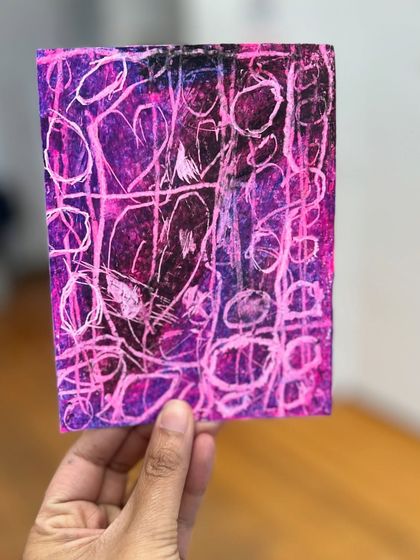 A vibrant pink and purple abstract piece filled with lines and shapes, created by one of our young students.