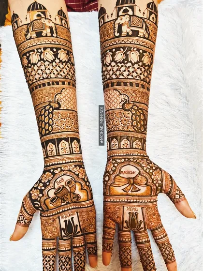 This is the kind of intricate bridal work that we are known for. This design features traditional motifs like elephants and palaces, combined with delicate floral patterns, covering the arms from elbow to fingertips.