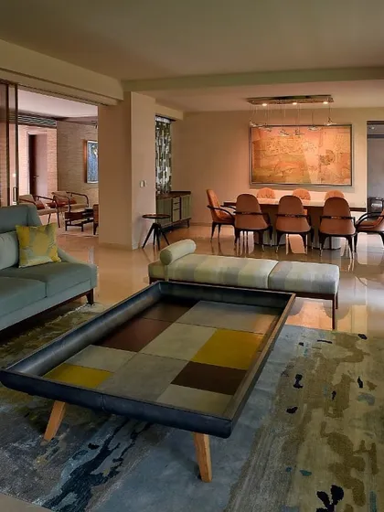 The open-plan living and dining area of the renovated Delhi home. The pastel color palette and custom furniture, like the Mondrian-inspired coffee table, create a space that is serene, artistic, and full of light.